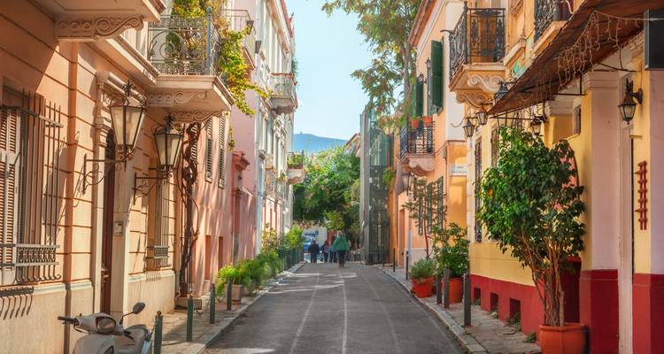 Una calle pintoresca con edificios coloridos y gente caminando por un camino estrecho.
