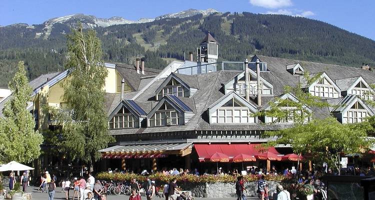 Zone de station de montagne avec magasins et population.