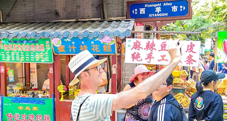 Menschen, die Selfies in einer bunten Marktgasse machen.