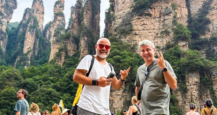Dos viajeros posan felizmente ante los espectaculares pilares de arenisca del Parque Forestal Nacional de Zhangjiajie