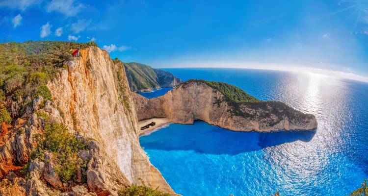 Panoramic view of Navagio Beach with clear blue water.
