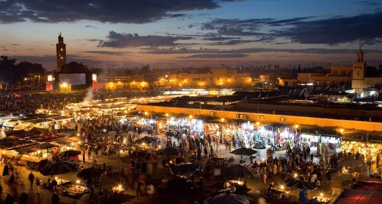 Levendige nachtmarkt met bruisende drukte en verlichte kraampjes.
