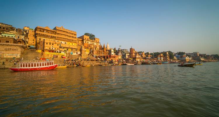 Busy riverside with historic ghats and people in Varanasi.