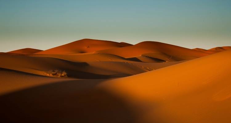 Wüstenlandschaft mit dramatischer Beleuchtung und Schatten.