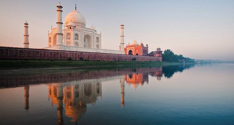 Taj Mahal reflecting in the river during day.
