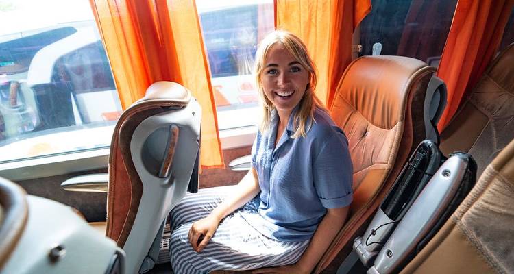 Personne assise à l'intérieur d'un bus avec des rideaux colorés.