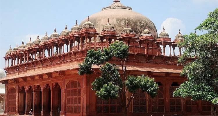 Red sandstone building with dome and arches.