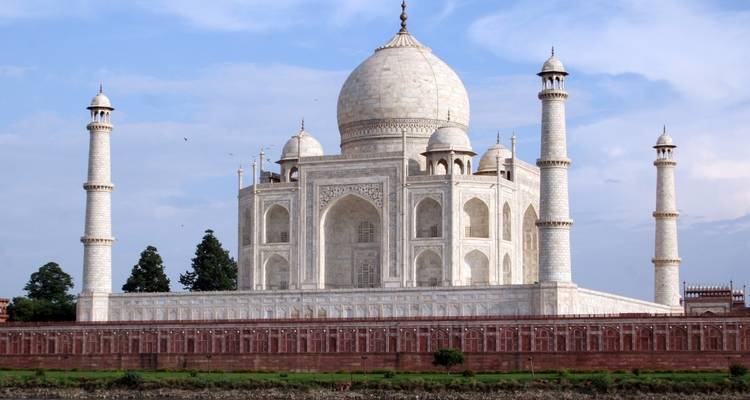 Ikonischer Blick auf das Taj Mahal mit Bäumen und Himmel.