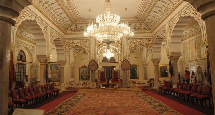 Lavishly decorated palace interior with chandeliers.