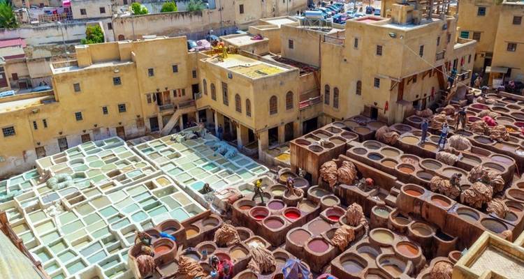 Tannerie à Fès, Maroc, avec des bassins de teinture colorés et des bâtiments.
