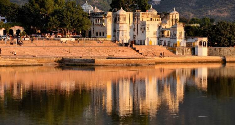 White palace on a lake reflecting the clear sky.
