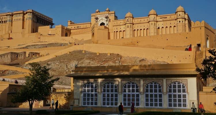Large fort with ancient architecture, people and trees visible.