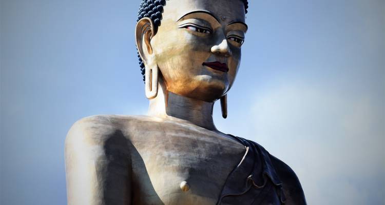 Estatua de bronce de Buda contra un cielo despejado