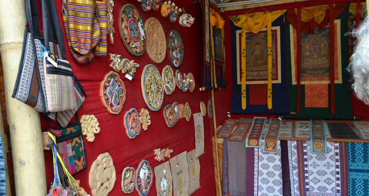 Puesto de mercado con artes y artesanías tradicionales butanesas en exhibición.