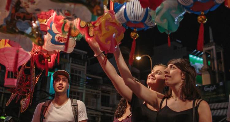 Grupo de amigos eligiendo recuerdos en un mercado nocturno vibrante.
