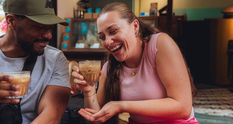 Les voyageurs partagent un café glacé vietnamien dans un café douillet, riant ensemble.