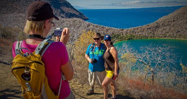 Groupe de personnes posant pour une photo au-dessus d'une baie pittoresque.