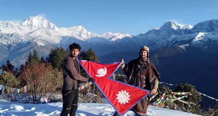 Twee mensen die een vlag vasthouden met bergen op de achtergrond.