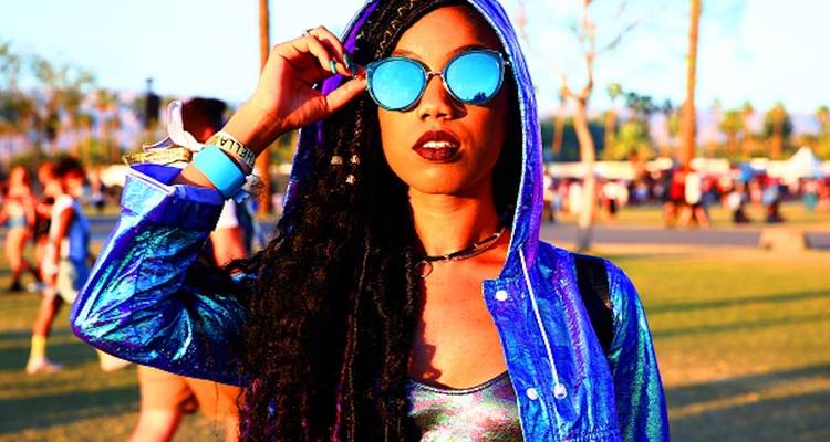 Femme portant des lunettes de soleil réfléchissantes à un festival.