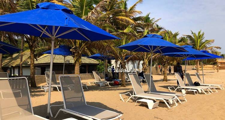 Plage avec des parasols et des chaises bleus, comportant un filigrane.