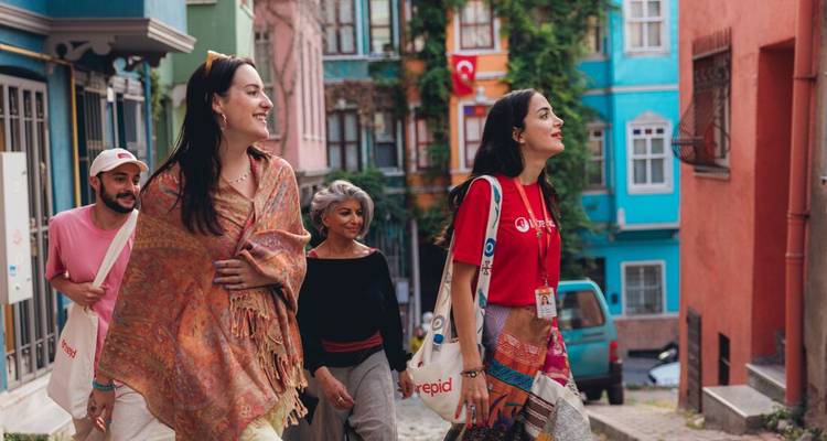 Petit groupe de voyageurs se promenant dans un quartier historique coloré rempli de façades vibrantes et de ruelles étroites.