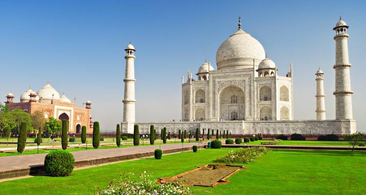 Taj Mahal met weelderige tuinen onder een heldere blauwe hemel.