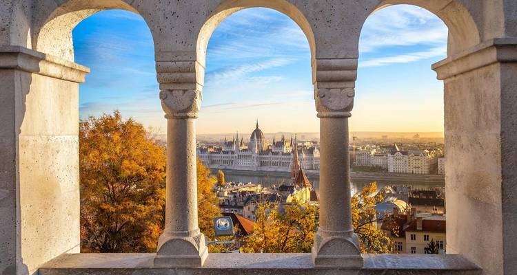 Vue de la ville de Budapest à travers des fenêtres cintrées avec feuillage d'automne.