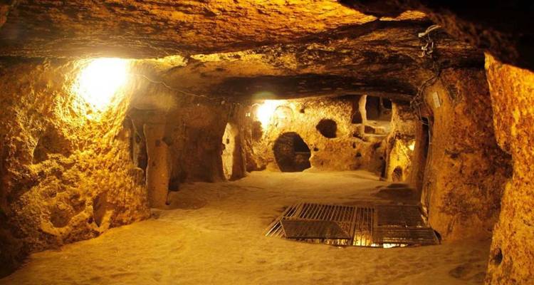 Tunnels souterrains avec un éclairage tamisé et des sols de sable.