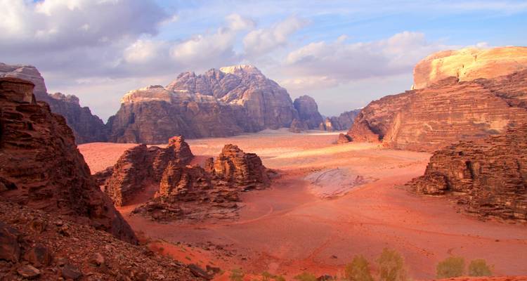 Sweeping view of a red desert landscape with mountains.
