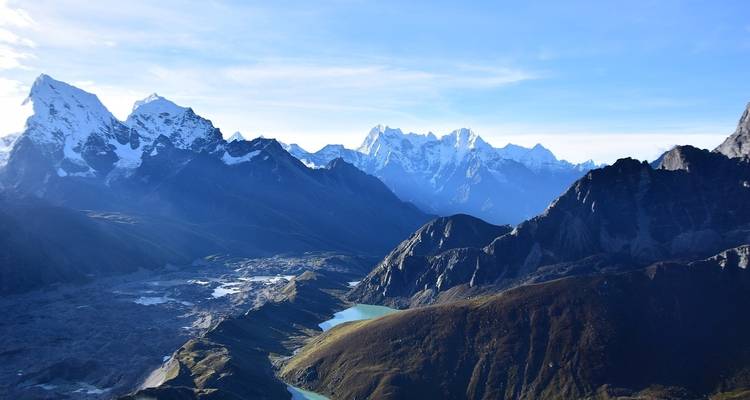 Vista aérea panorámica de lagos glaciares y imponentes cordilleras del Himalaya bajo la nítida luz matutina.