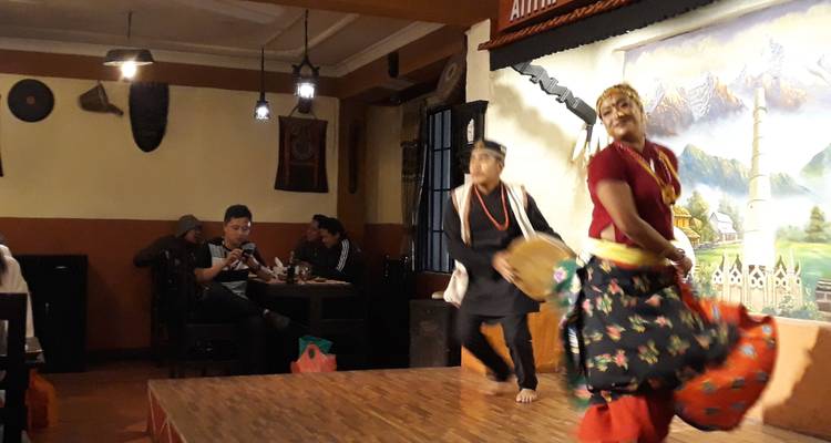 Indoor cultural performance with people dressed in traditional attire.
