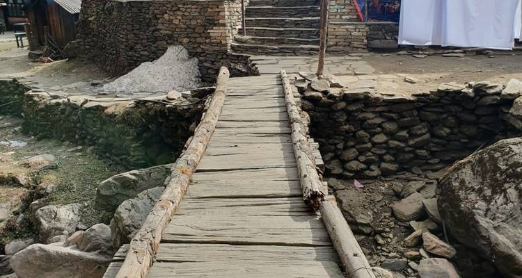 Houten brug die naar stenen trappen leidt.