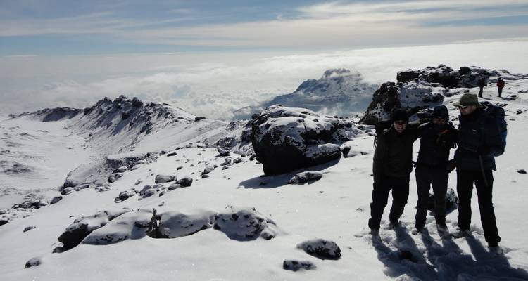 Randonneurs sur un plateau enneigé avec une vue panoramique.