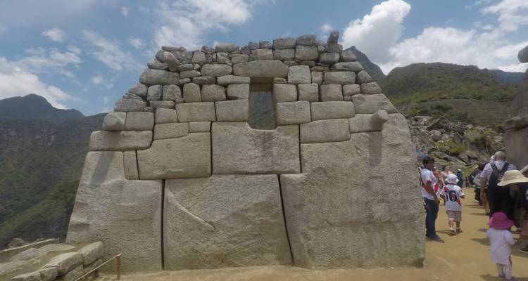 Stone wall with an opening and tourists in the background.