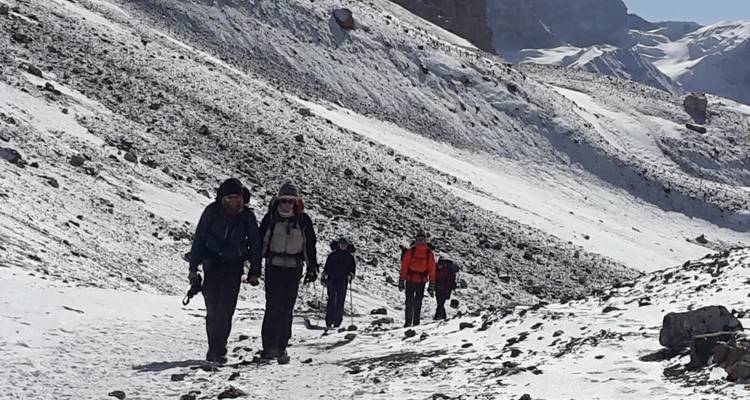 People hiking through snow-covered path.