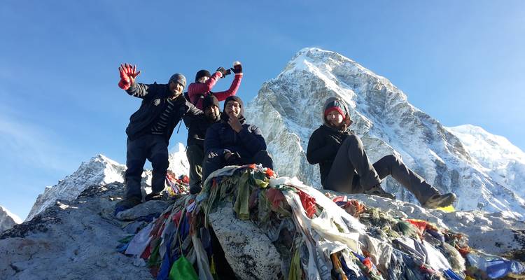 Group of people with mountain backdrop and flags.