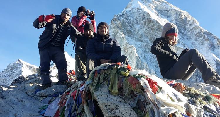 Group of trekkers near a snow-covered peak.