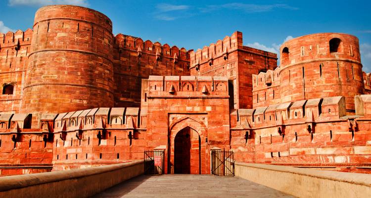 The exterior of the Red Fort in Agra with a blue sky.