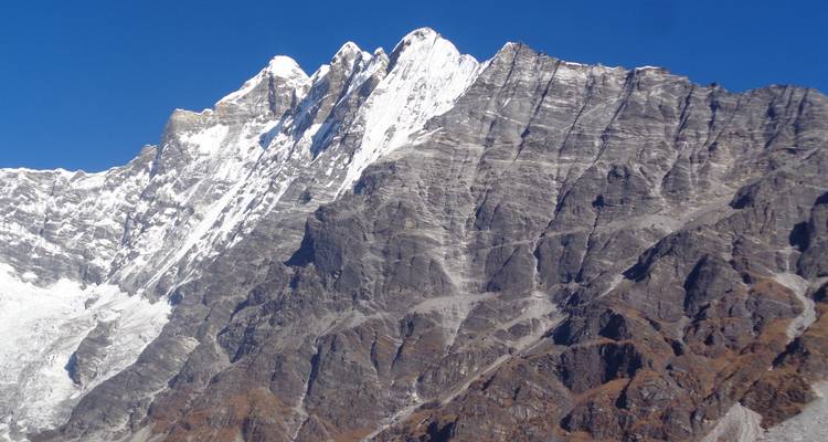 Besneeuwde bergen onder een strakblauwe hemel.
