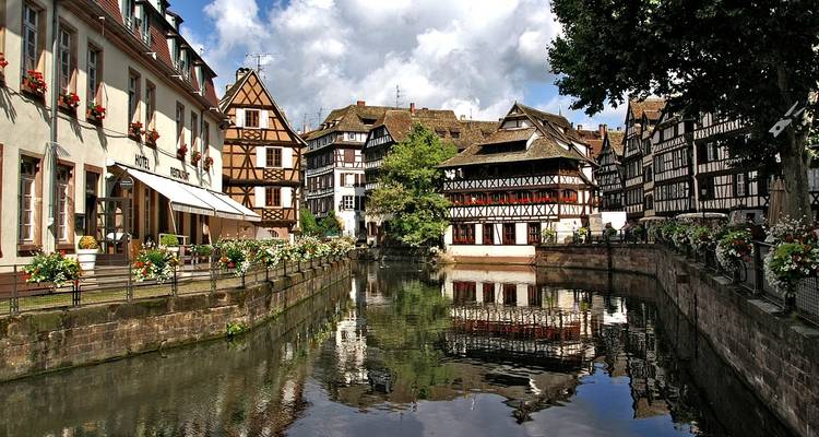 Encantadora vista del canal bordeada de casas de entramado de madera decoradas con flores en el casco antiguo de Estrasburgo.