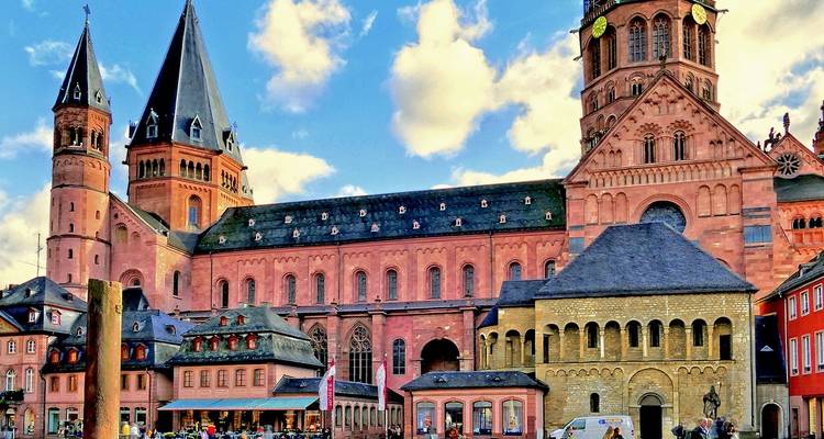 Catedral de Maguncia de piedra arenisca roja y plaza histórica circundante bajo un cielo brillante.