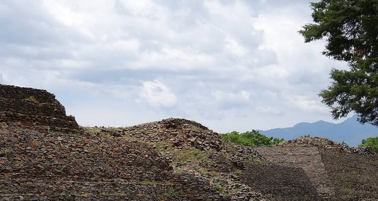 Ruinas de antiguas estructuras de piedra bajo cielos nublados.