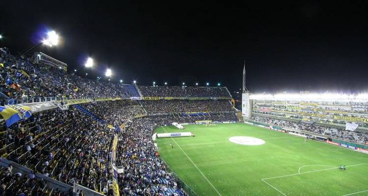 Nachtelijk voetbalstadion vol met toeschouwers.