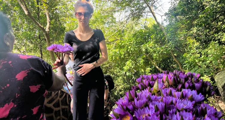 Personne tenant des fleurs violettes au milieu d'une conversation.