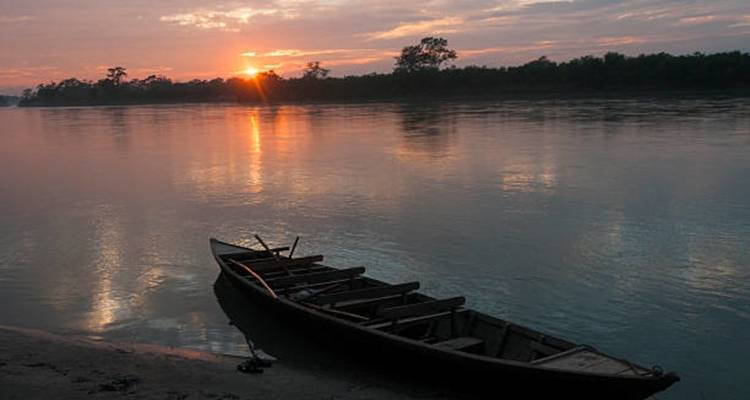 Coucher de soleil sur une rivière avec un bateau solitaire