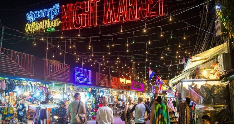 Nachtmarkt mit lebendigen Neonschildern und einkaufenden Menschen.