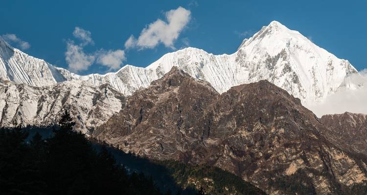 Majestic view of snowy peak mountains under a bright blue sky.