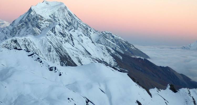 Snow-covered mountain landscape during sunrise.