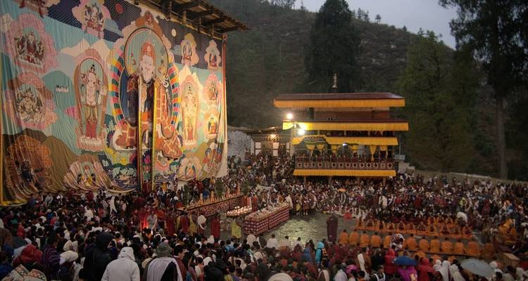 Large gathering at a religious festival with a decorated facade.