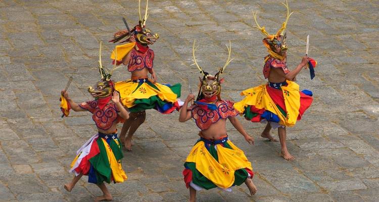 Dancers in colorful masks and costumes performing.